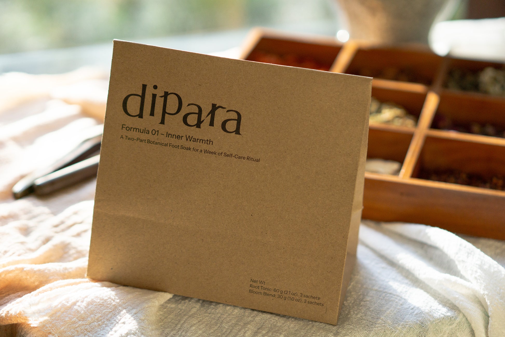 Dipara Formula 01 Inner Warmth herbal foot soak discovery set box displayed in warm natural light, styled in a calm home setting.