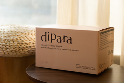 Dipara Formula 01 Inner Warmth herbal foot soak packaging styled in soft natural light, reflecting a calm and cozy self-care ritual setting.